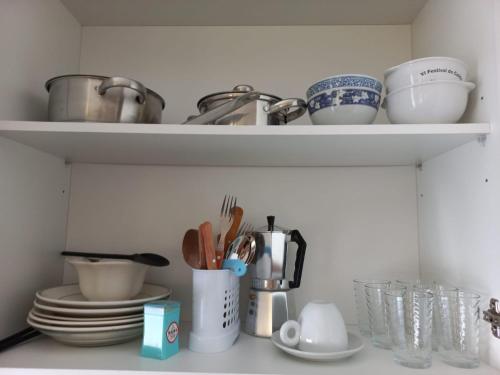 a kitchen shelf with dishes and utensils on it at Studios Rossio in Viseu