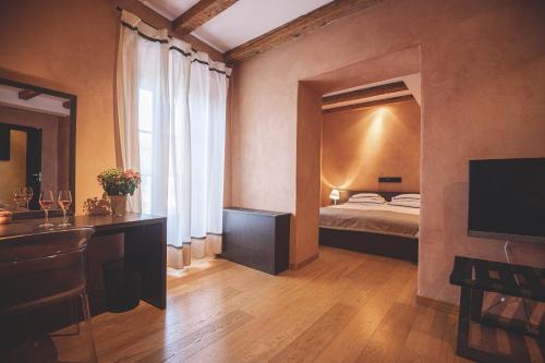 a bedroom with a bed and a desk and a television at Heritage Hotel Kukuriku in Kastav