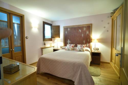 a bedroom with a bed with two pillows on it at Cal Fuster De La Plaça in San Martín de Tous