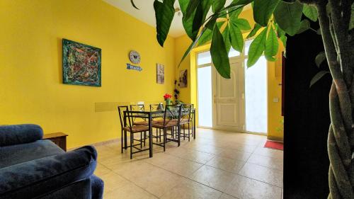 een woonkamer met een tafel en stoelen en gele muren bij Apartamento Rosellón in Barcelona
