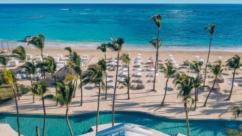 uma vista para uma praia com palmeiras e uma piscina em Private Villa LaPerla Iberosta 3BDR, Pool, Beach, WiFi em Punta Cana