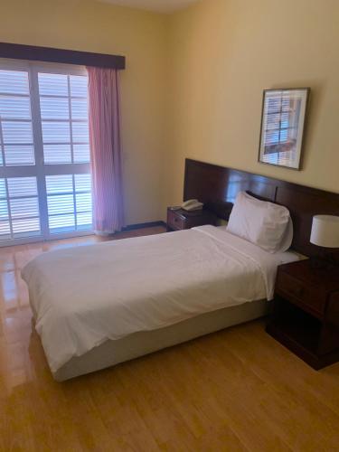 a bedroom with a large white bed and a window at Casa De Cha Prazeres in Prazeres