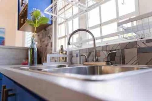 um balcão de cozinha com um lavatório e uma janela em Playa y Campo Getaway Apartment, with Hot Tub em Isabela