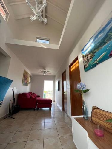 a living room with a red couch and a ceiling at Playa y Campo Getaway Apartment in Isabela