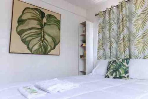 a bedroom with a bed with a painting on the wall at Playa y Campo Getaway Apartment, with Hot Tub in Isabela
