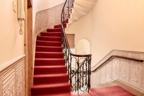una escalera en una casa con alfombra roja en Beautiful Grade II listed apartment., en Leek