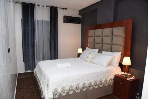 um quarto com uma cama grande e uma janela em Haut-Standing- Appartement-Fes-City em Fez