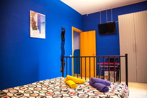 バルセロナにあるApartamento Rosellónの青い壁のベッドルーム1室、カラフルな枕付きのベッド1台が備わります。