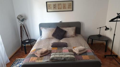 a bed with a blanket and pillows on it at Casa Arion in Băile Herculane