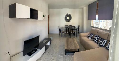 a living room with a couch and a tv at Alhambra Apartments in Granada