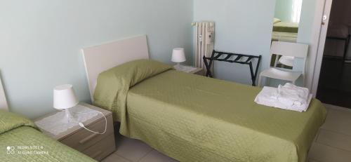 a small bedroom with a green bed and a chair at Affittacamere "SAN MARTINO ROOMS" in Genova