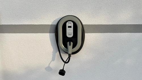 um dispositivo electrónico preto pendurado numa parede em Apartments Apple Garden 4P em Bled