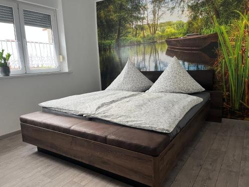 Bett in einem Zimmer mit einem Bild eines Flusses in der Unterkunft Kahnstübchen in Lübben