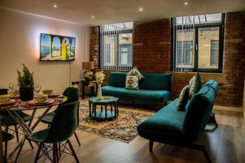 ein Wohnzimmer mit grünen Möbeln und einem Tisch in der Unterkunft BV Lush Apartment At Conditioning House Bradford in Bradford