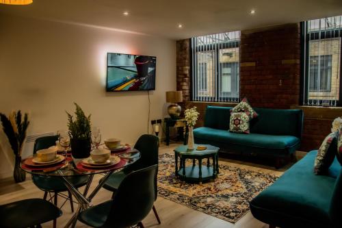 ein Wohnzimmer mit einem Tisch und grünen Möbeln in der Unterkunft BV Lush Apartment At Conditioning House Bradford in Bradford