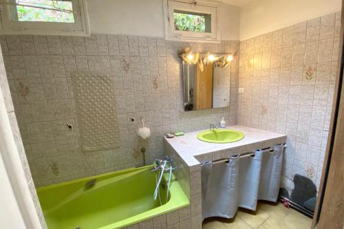 W łazience znajduje się zielona wanna i umywalka. w obiekcie Locquenole house with sea view w mieście Locquénolé