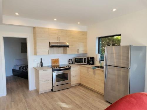 a kitchen with a stainless steel refrigerator and a bed at J and Js in Bowen Island