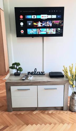 a tv hanging on a wall in a living room at Apartman Sky in Bijeljina