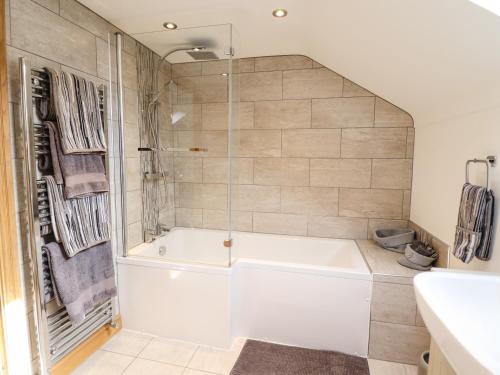 uma casa de banho com uma banheira branca e um chuveiro em Tyn Y Ceubren Bach at Evelyns Retreat em Corwen