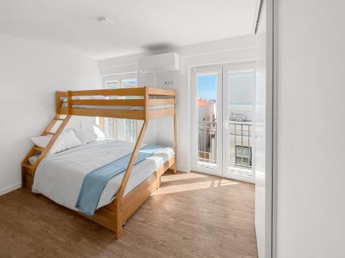 a bedroom with a bunk bed and a balcony at Sea Light Apartment Sesimbra. 2 bedrooms, 6 guests in Sesimbra