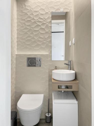 a bathroom with a white toilet and a sink at Sea View Apartment, Steps from the Beach, Sesimbra in Sesimbra