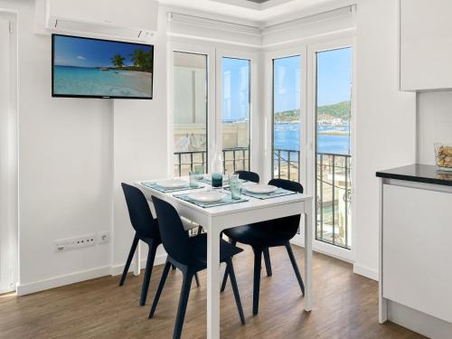 a white dining room with a white table and chairs at Sea View Apartment, Steps from the Beach, Sesimbra in Sesimbra