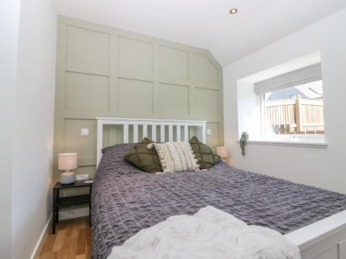 a bedroom with a large bed and a window at Lindsay Cottage in Kirriemuir