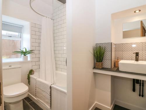 biała łazienka z toaletą i umywalką w obiekcie Lindsay Cottage w mieście Kirriemuir