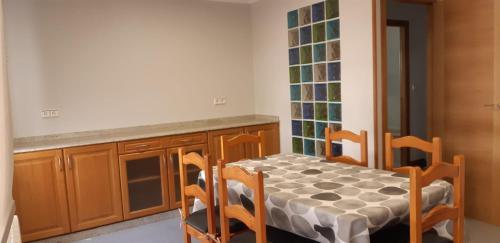 uma cozinha com uma mesa e cadeiras numa cozinha em Apartamento Alba no Portonovo