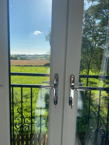 a door to a balcony with a view of a field at Wilkinson farm in Blackrod
