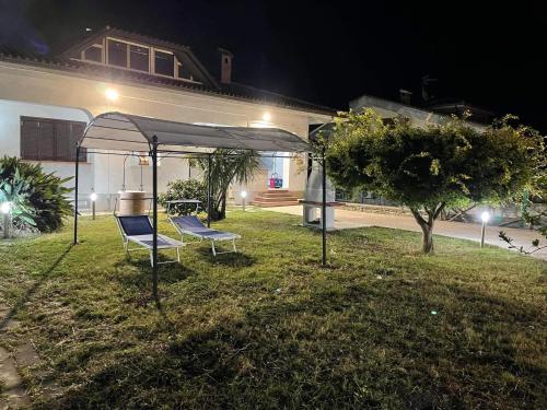 two chairs under a tent in a yard at night at Villa Lidia & Attico degli artisti, free pets , giardino recintato e attrezzato in Minturno