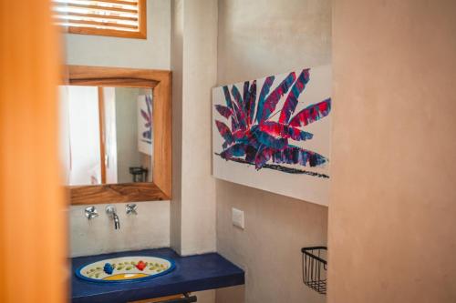 een badkamer met een wastafel en een spiegel bij Casa Hotel El Porton SALENTO in Salento