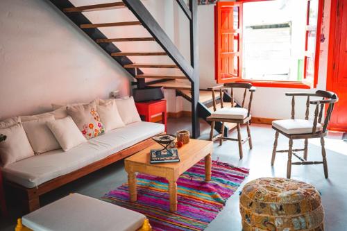 een woonkamer met een bank en een tafel en stoelen bij Casa Hotel El Porton SALENTO in Salento