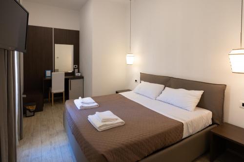 ローマにあるMaison Maneliのベッドルーム1室(ベッド1台、タオル2枚付)