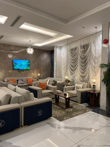 uma sala de estar com sofás e uma televisão na parede em فندق التلال الخضراء em An Nimāş