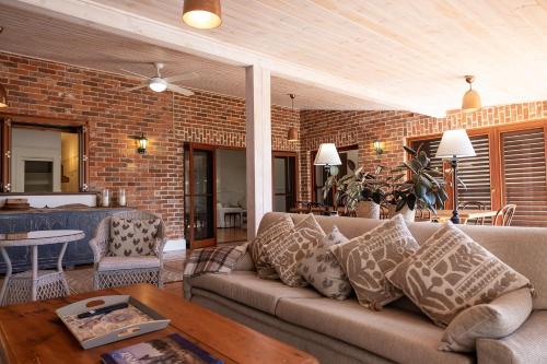 a living room with a couch and a brick wall at Mia Mia Mudgee in Mudgee