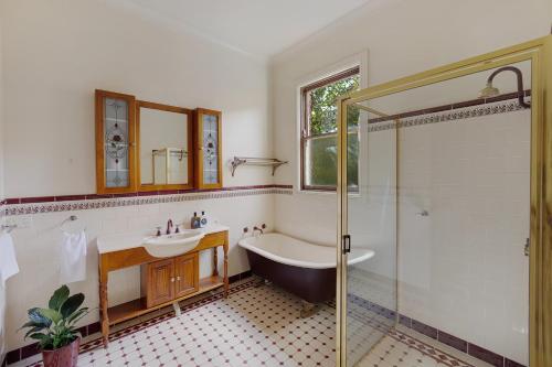 a bathroom with a tub and a sink and a shower at Mia Mia Mudgee in Mudgee
