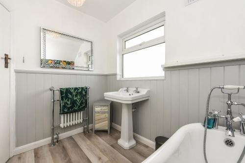 a bathroom with a white tub and a sink at Merriesands, Middleton - On - Sea in Middleton-on-Sea