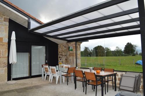 a patio with a wooden pergola and a table and chairs at Las Azadas in Tezanos
