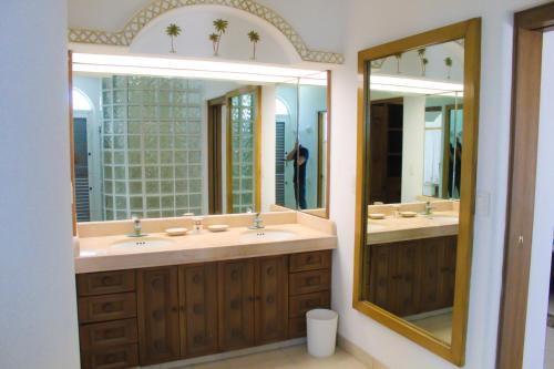 a bathroom with two sinks and two mirrors at Villa Santorini in Uaymitun