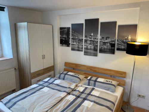 a bedroom with a bed and some paintings on the wall at 4 Betten in 3-Zimmer-Wohnung mit WLAN TV und Garten in Schwieberdingen