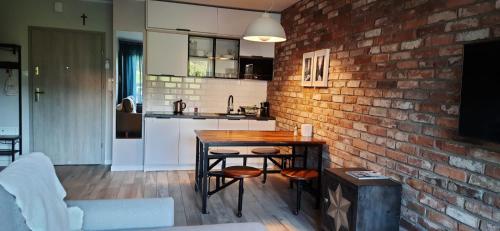 a kitchen and living room with a brick wall at Apartament Górski Widok Szklarska Poręba in Szklarska Poręba