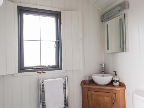 a bathroom with a sink and a window at Shepherds Hut in Lonmore
