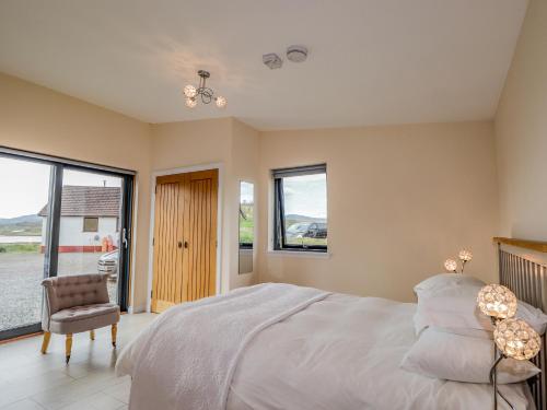 una camera con letto, sedia e finestre di The Cabin a Lonmore