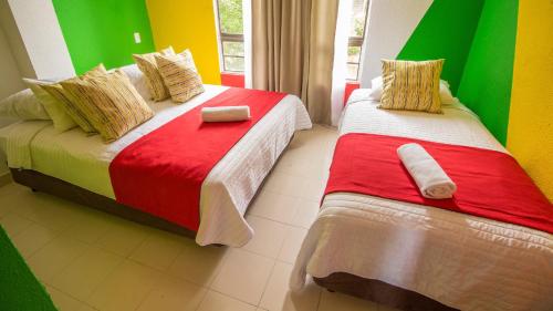 2 camas en una habitación con paredes coloridas en Posada Magic Hill On Vacation en San Andrés