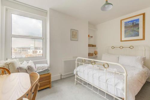 ein weißes Schlafzimmer mit einem weißen Bett und einem Fenster in der Unterkunft Worthing sea-front 3 bed apartment in Worthing