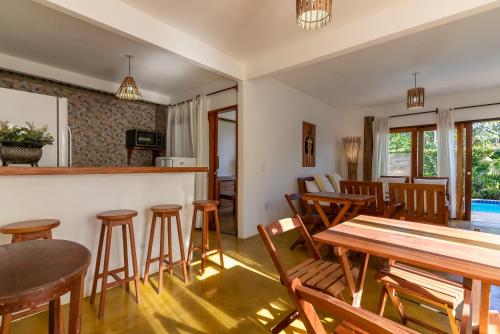 una sala da pranzo con tavoli e sedie in legno di Casa Luar Trancoso a Trancoso
