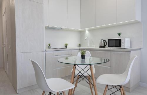a kitchen with a table and chairs and a microwave at Люкс на Бориспільській ЖК Олімпік Парк, генератор на будинку in Kyiv