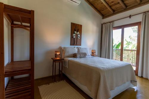 a bedroom with a large bed and a window at Casa Luar Trancoso in Trancoso