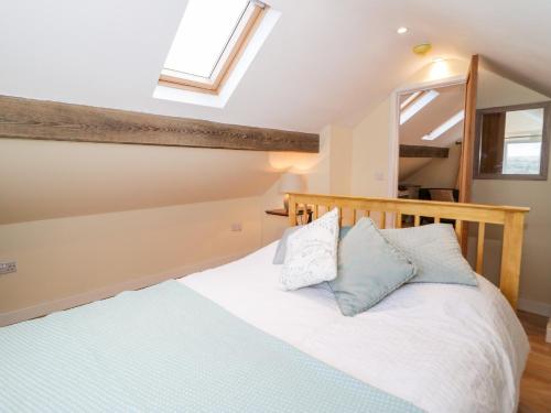 Schlafzimmer mit einem Bett mit blauen und weißen Kissen in der Unterkunft Bryn Dedwydd Cottage in Betws-y-coed